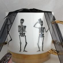 Load image into Gallery viewer, Halloween Elegance White+ Gold + Black Whimsical Skeletons Posing Coffee Tea Cups + Sauce…