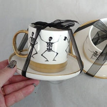 Load image into Gallery viewer, Halloween Elegance White+ Gold + Black Whimsical Skeletons Posing Coffee Tea Cups + Sauce…